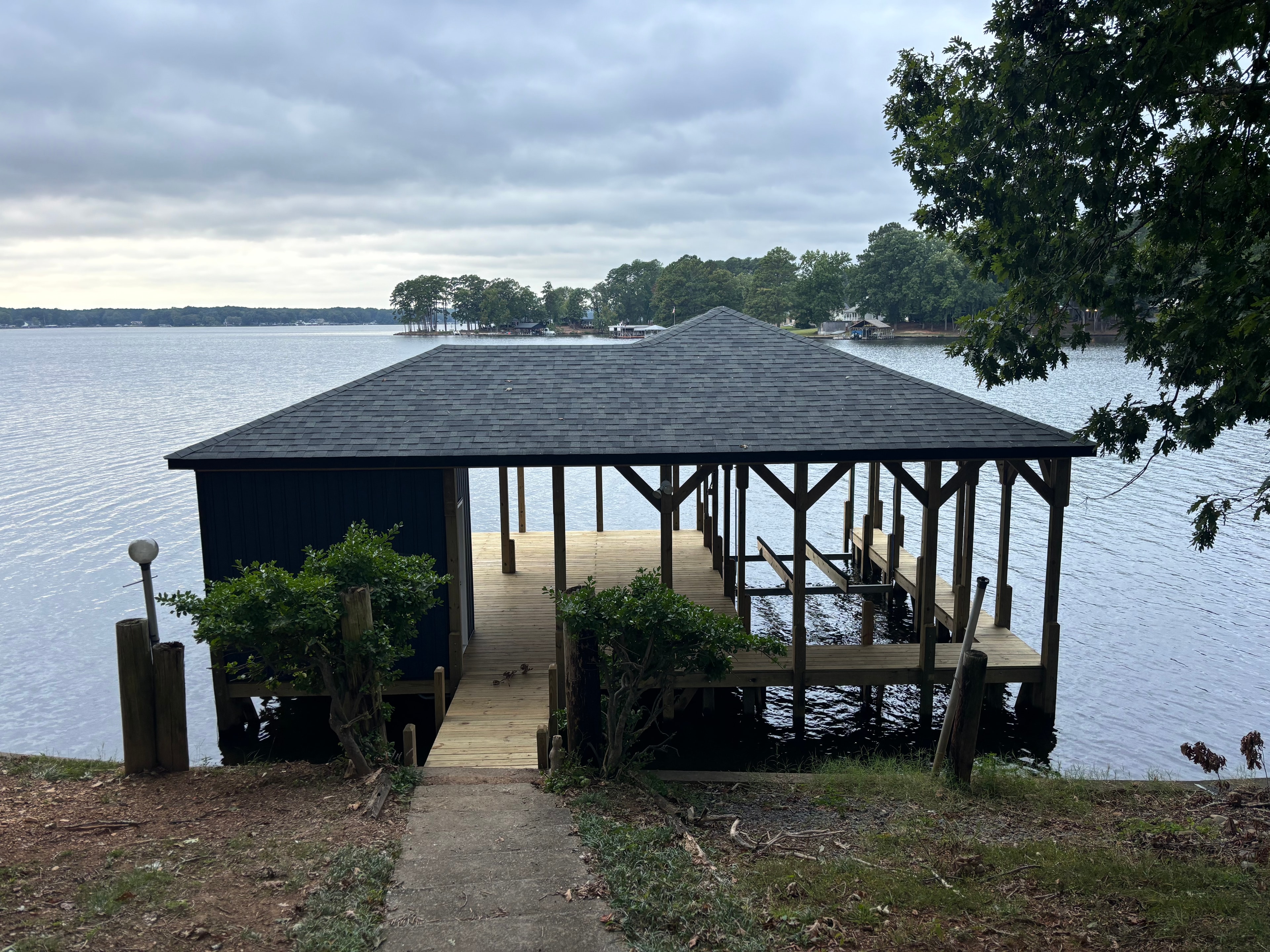 SHT Construction — completed boathouse with dark roof and open dock