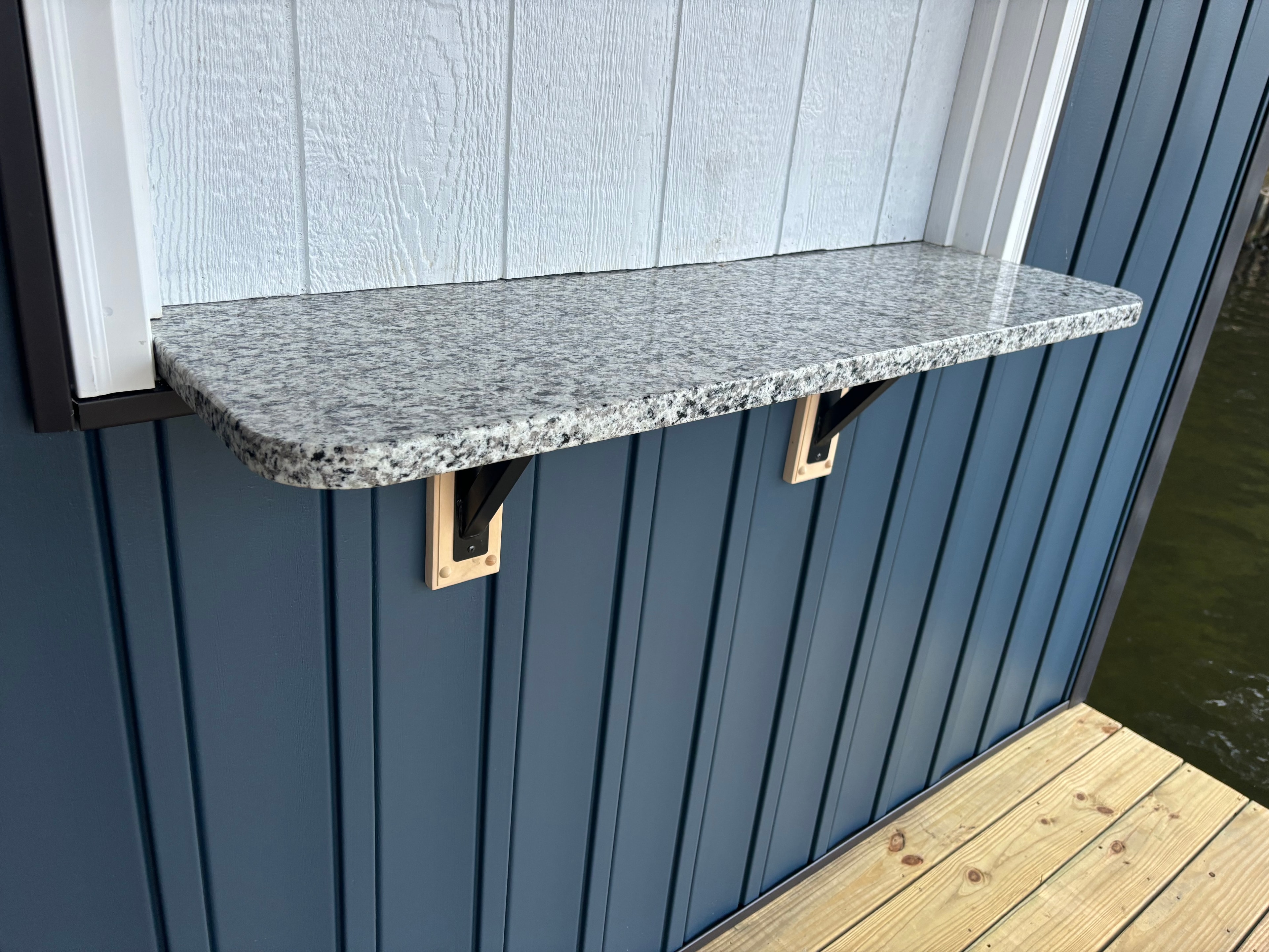 SHT Construction — granite countertop shelf detail on boathouse exterior