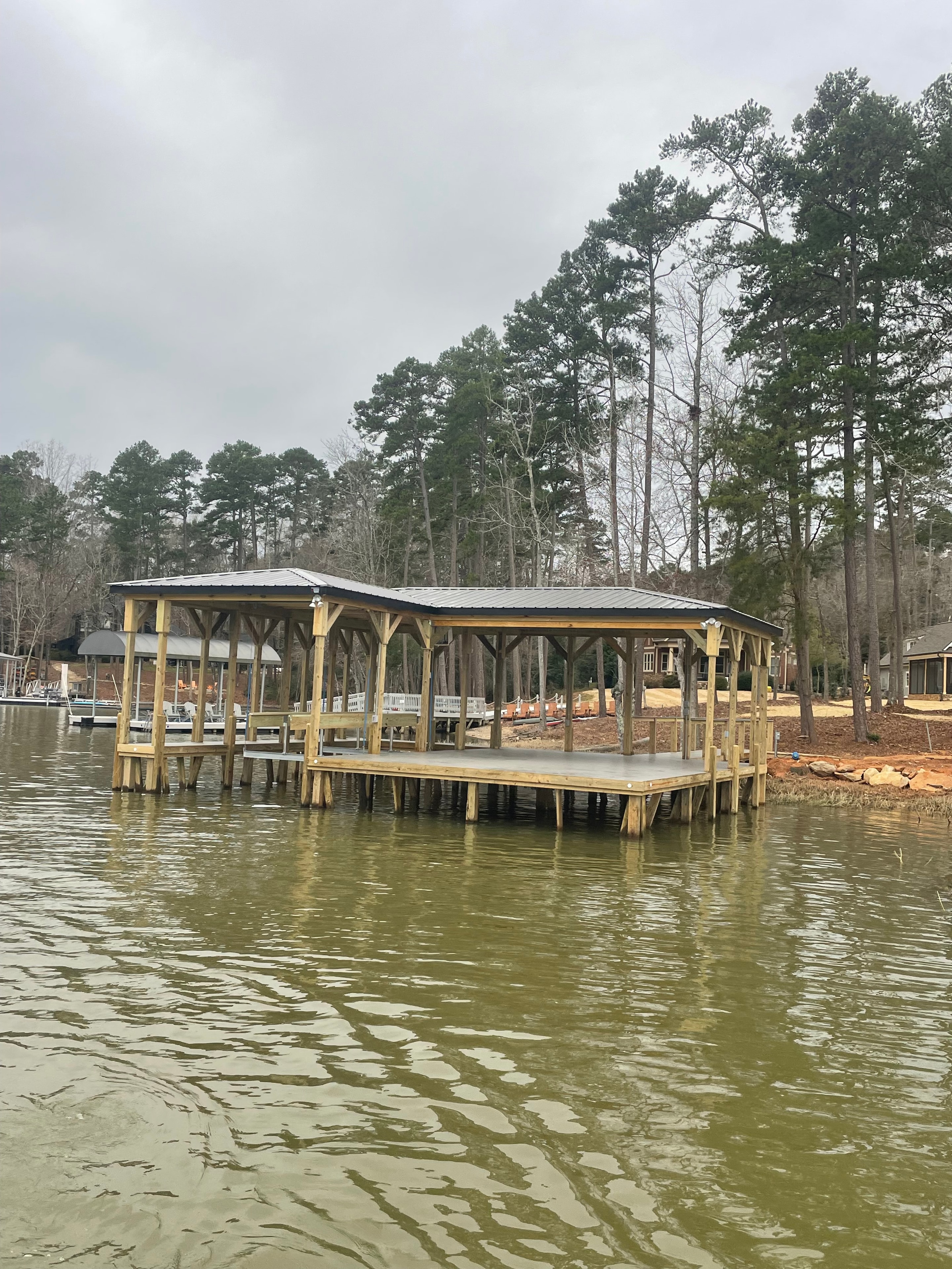 SHT Construction — boathouse structure viewed from the water showing full dock framing